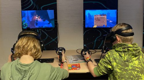 Jongens spelen Minecraft met VR-brillen en controllers