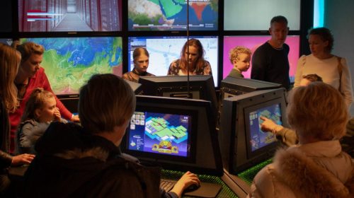 Gezinnen spelen het energietransitiespel op schermen