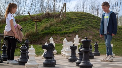 Kinderen spelen levensgroot schaak in de speurtuin